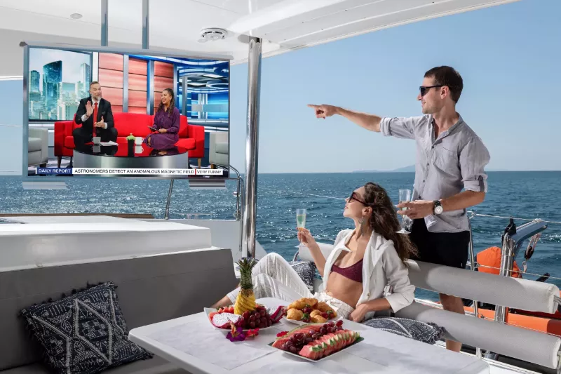 Watching a show on the yacht with a cool beverage from the Cosmos outdoor TV located in the ceiling.